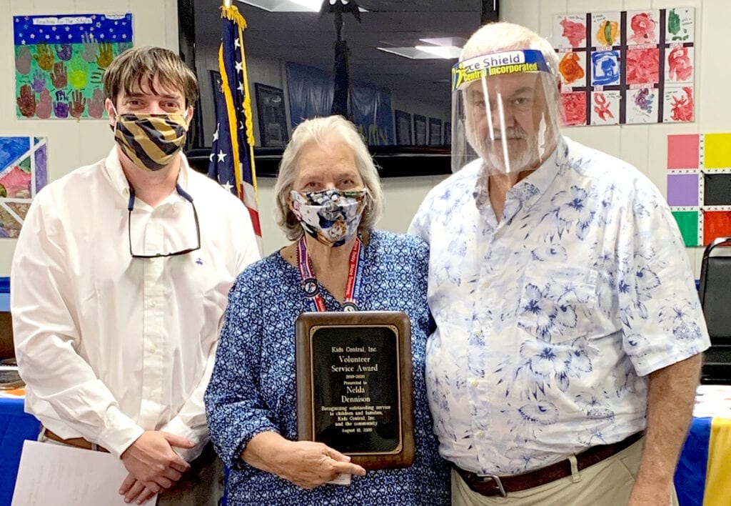 MEOC foster grandparent Nelda ‘Moe’ Dennison (center) is this year’s recipient of Kids Central Inc.’s Volunteer of the Year Award. Presenting the award at Kids Central’s August board meeting is chairman Will Sturgill (left) and executive director Darrell Edwards.